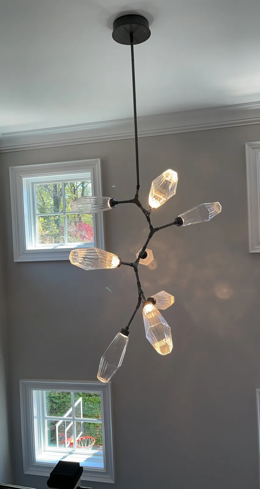 Modern branching chandelier installed in a two-story foyer