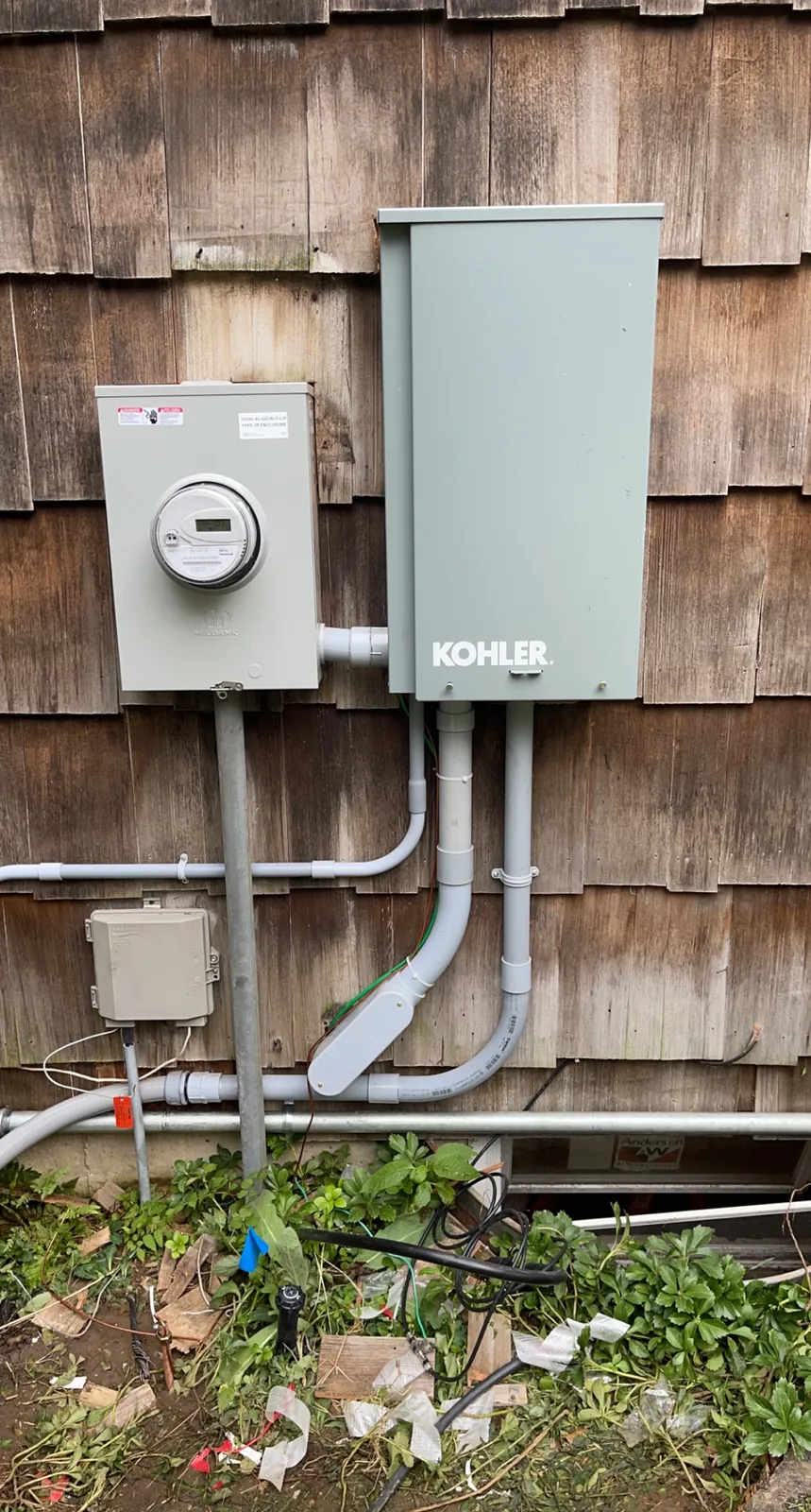 Standby generator disconnect and utility meter mounted on cedar shake siding