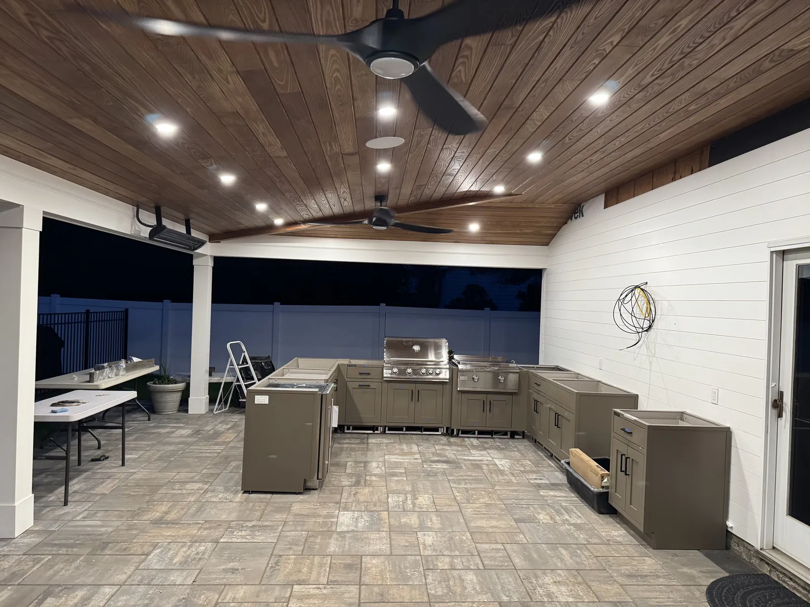 Recessed lighting and ceiling fans installed in a covered outdoor kitchen
